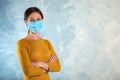 Woman with disposable mask on face against blue background. Space for text Royalty Free Stock Photo