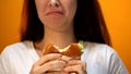 Woman dissatisfied with unappetizing hamburger, low food quality, closeup Royalty Free Stock Photo
