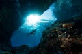 woman diver underwater at the entrance of a cave with sunrays Royalty Free Stock Photo