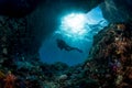 woman diver underwater at the entrance of a cave with sunrays Royalty Free Stock Photo