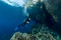 woman diver underwater at the entrance of a cave with sunrays Royalty Free Stock Photo