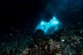 woman diver underwater at the entrance of a cave with sunrays Royalty Free Stock Photo