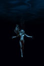 Woman Diving in the dark sea.