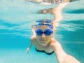 A woman with diving glasses is swimming in the pool under the water Royalty Free Stock Photo