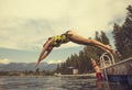 Woman diving off the dock of lake while on summer vacation Royalty Free Stock Photo