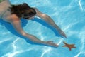 Woman diving for starfish