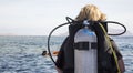 Woman in diving suit with aqualung ready to dive into sea