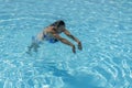 Woman diving in the swimming pool. Young beautiful girl swimming in pool. Brunette relaxing in clear warm water on sunny day. Top Royalty Free Stock Photo