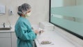 Woman doctor assistant in gloves is wiping odontic instruments after washing