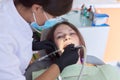 Woman doctor dentist treating teeth to girl patient in dental office Royalty Free Stock Photo