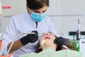 Woman doctor dentist treating teeth to girl patient in dental office Royalty Free Stock Photo