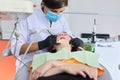 Woman doctor dentist treating teeth to girl patient in dental office Royalty Free Stock Photo