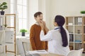 Woman doctor endocrinologist or otolaryngologist is examining her child patient