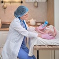 Woman doctor feeding a newborn baby from a bottle. Nurse gives water to the child