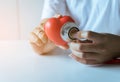 Woman doctor hands holding stethoscope to checking red heart from patient,Health care checking concept Royalty Free Stock Photo