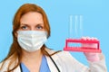 Woman doctor holding test tubes on a blue background, close-up Royalty Free Stock Photo