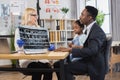 Woman doctor holding x-ray scan, talking with black-skinned father with cute mixed race daughter Royalty Free Stock Photo