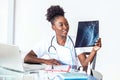 Woman doctor in hospital looking at x-ray film healthcare, roentgen, people and medicine concept. Young smiling female doctor with Royalty Free Stock Photo