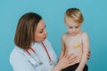 Woman doctor measures the temperature of a little boy Royalty Free Stock Photo