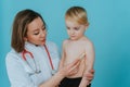 Woman doctor measures the temperature of a little boy Royalty Free Stock Photo