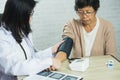 Woman doctor measuring blood pressure for elderly female patient on the doctor\'s office desk. Elderly female patient Royalty Free Stock Photo