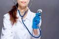 Woman doctor in medical clothes holds a stethoscope on a black background Royalty Free Stock Photo