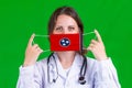 Woman doctor in a medical coat holds a medical mask with of the Tennessee flag