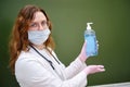 A woman doctor in a medical mask stands at a school board with a sanitizer in her hand. Learning difficulties in the flu pandemic