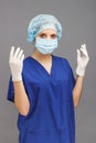 Woman doctor in the medical uniform, with sterile gloves on the hands and a mask on the face Royalty Free Stock Photo