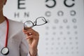 Woman doctor ophthalmologist shows glasses, close-up, blurry Royalty Free Stock Photo