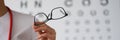 Woman doctor ophthalmologist shows glasses, close-up, blurry Royalty Free Stock Photo