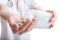 Woman doctor pouring pills on hand