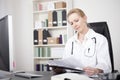 Woman Doctor Reading Medical Reports at her Office Royalty Free Stock Photo