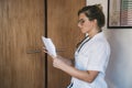 Woman doctor reading papers in office Royalty Free Stock Photo