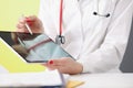 Woman doctor showing information on digital tablet in clinic closeup Royalty Free Stock Photo