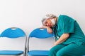 Woman doctor is sitting and fall asleep, because of worry, frustration, tiredness and exhausting of global infection Royalty Free Stock Photo