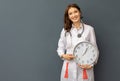 Woman doctor smiles and shows big clock