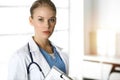 Woman - doctor standing in sunny clinic. Physician at work, studio portrait Royalty Free Stock Photo