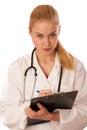 Woman doctor with stethoscope around neck writing illness symptoms of pacient on clipboard.