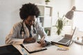 Woman doctor with stethoscope looking at medical papers at her office working hard Royalty Free Stock Photo