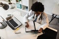 Woman doctor with stethoscope looking at medical papers at her office working hard Royalty Free Stock Photo