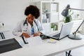 Woman doctor with stethoscope looking at medical papers at her office working hard Royalty Free Stock Photo