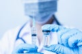 Woman doctor with stethoscope wearing face mask protective in the laboratory holding syringe and medicine vial vaccine Royalty Free Stock Photo