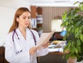 Woman doctor studying clinical diagnosis of patient in medical office Royalty Free Stock Photo