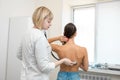 Woman doctor therapist listening with a stethoscope to a back, young female patient Royalty Free Stock Photo