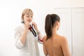 Woman doctor therapist listening with a stethoscope to a back, young female patient Royalty Free Stock Photo