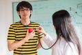 Woman doctor using stethoscope listen heart beat sound from red heart plastic on hand of patient.