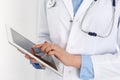 Woman doctor using tablet computer while standing straight in hospital closeup. Healthcare, insurance and medicine Royalty Free Stock Photo