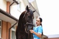 Woman doctor veterinarian stroking thoroughbred horses on farm Royalty Free Stock Photo