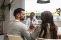 Woman doctor visits a young married couple in their home and gives health consultations. Female medical worker in a patients Royalty Free Stock Photo